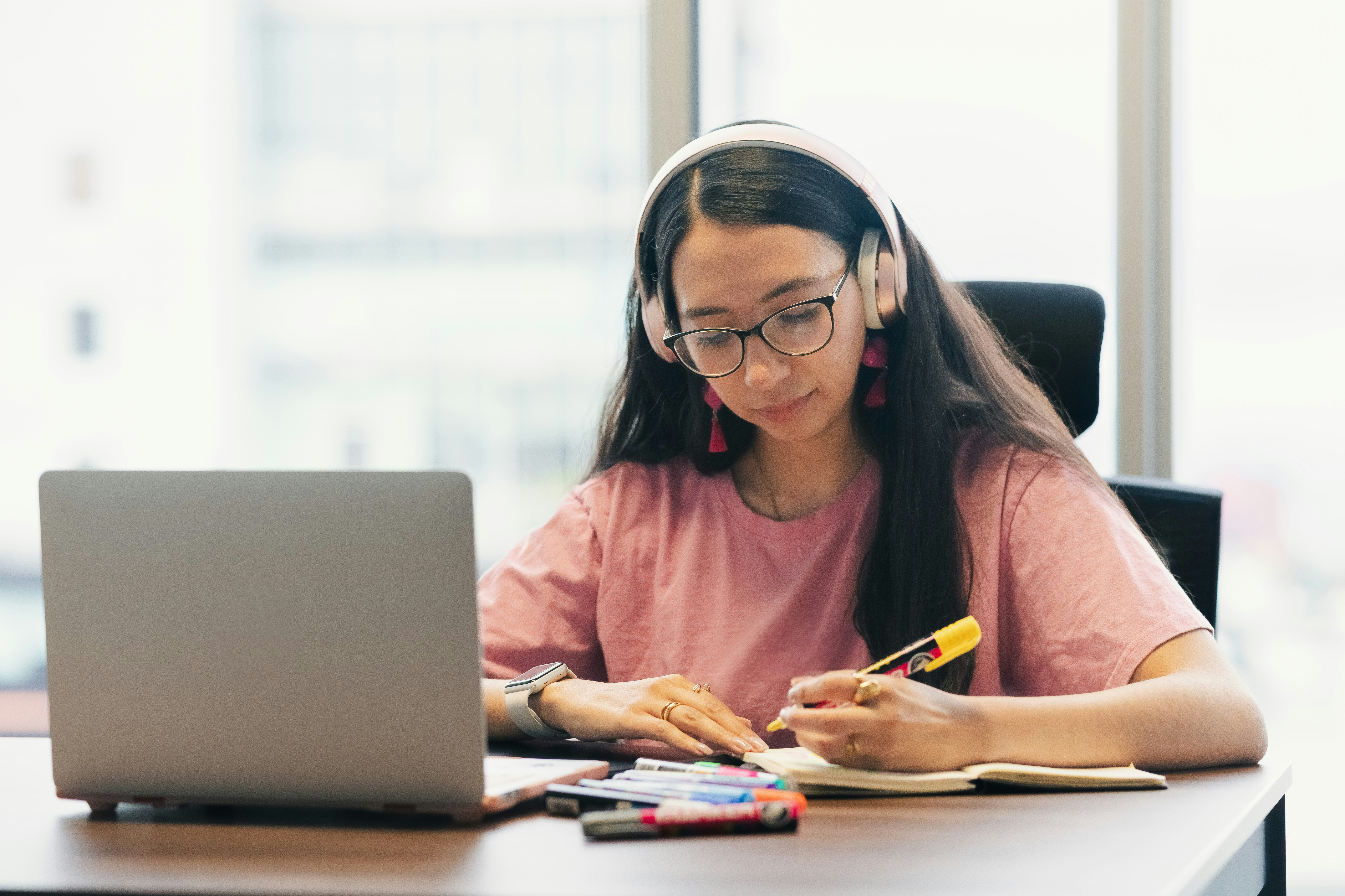 Learn@Home - Studentin mit Kopfhörern beim Lernen am Laptop