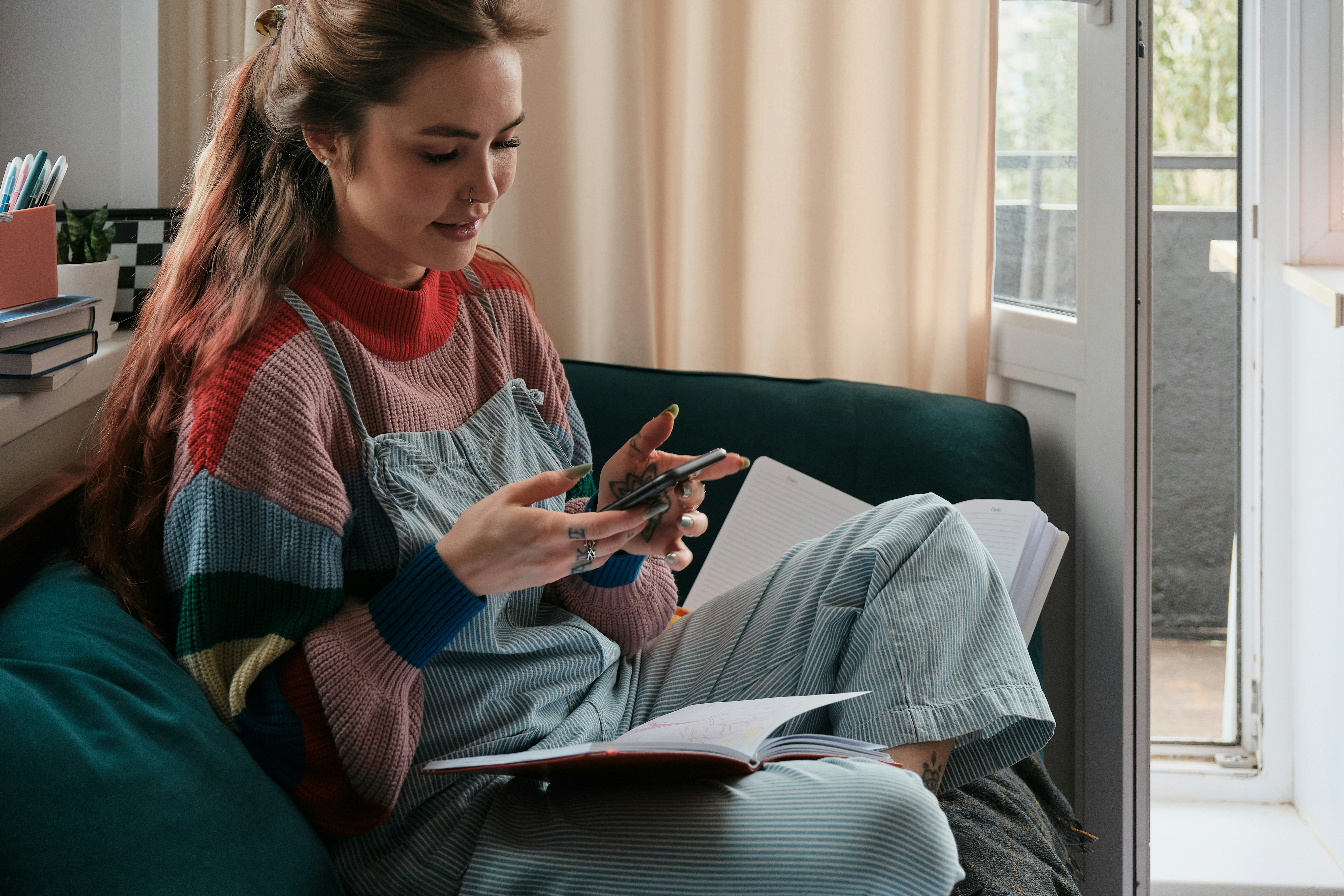 Learn@Home - Studentin beim Online-Lernen mit Smartphone und Lernunterlagen