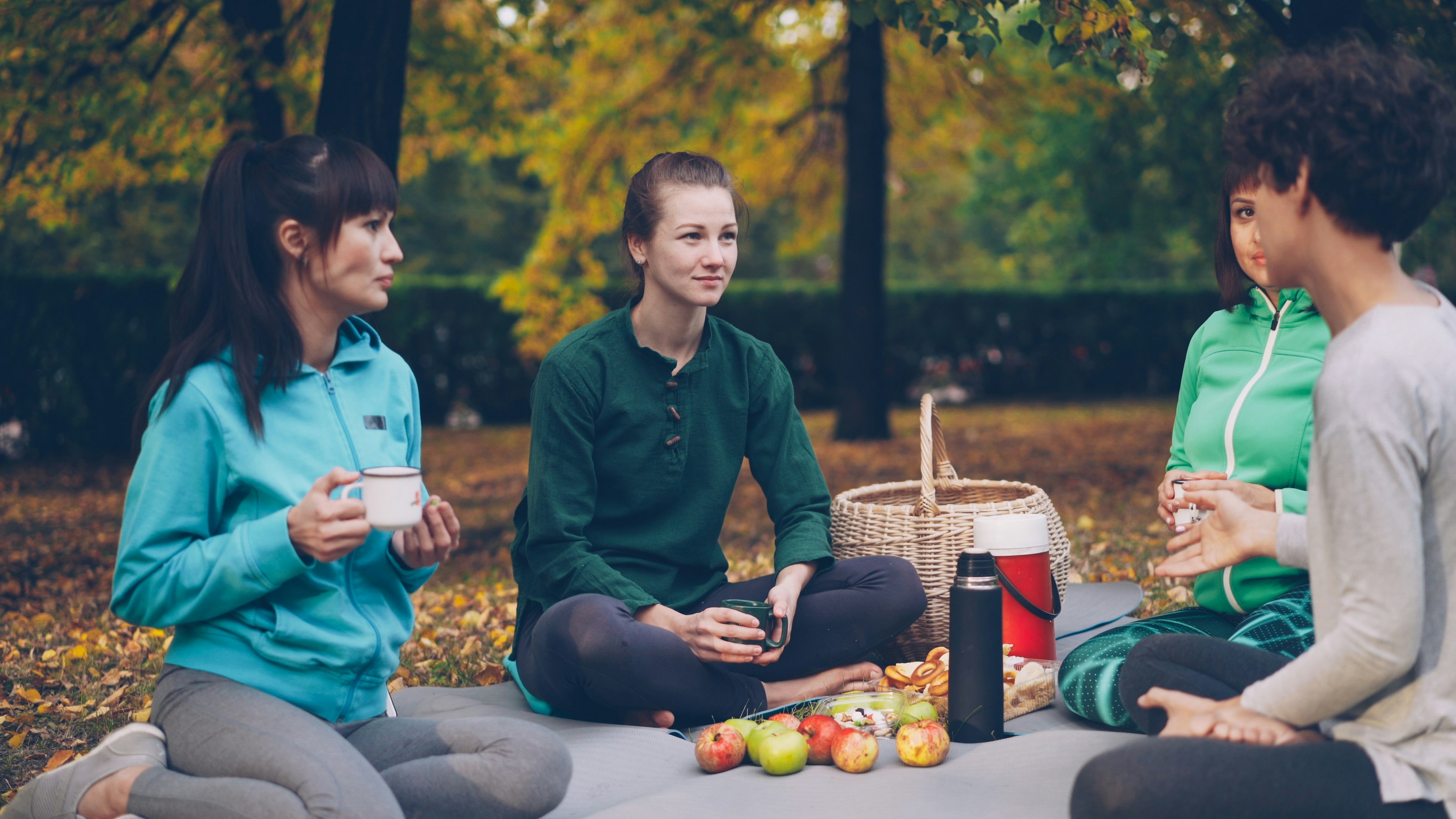 Learn@Home - Gruppe von Frauen sitzt bei einem gemeinsamen Austausch im herbstlichen Park.