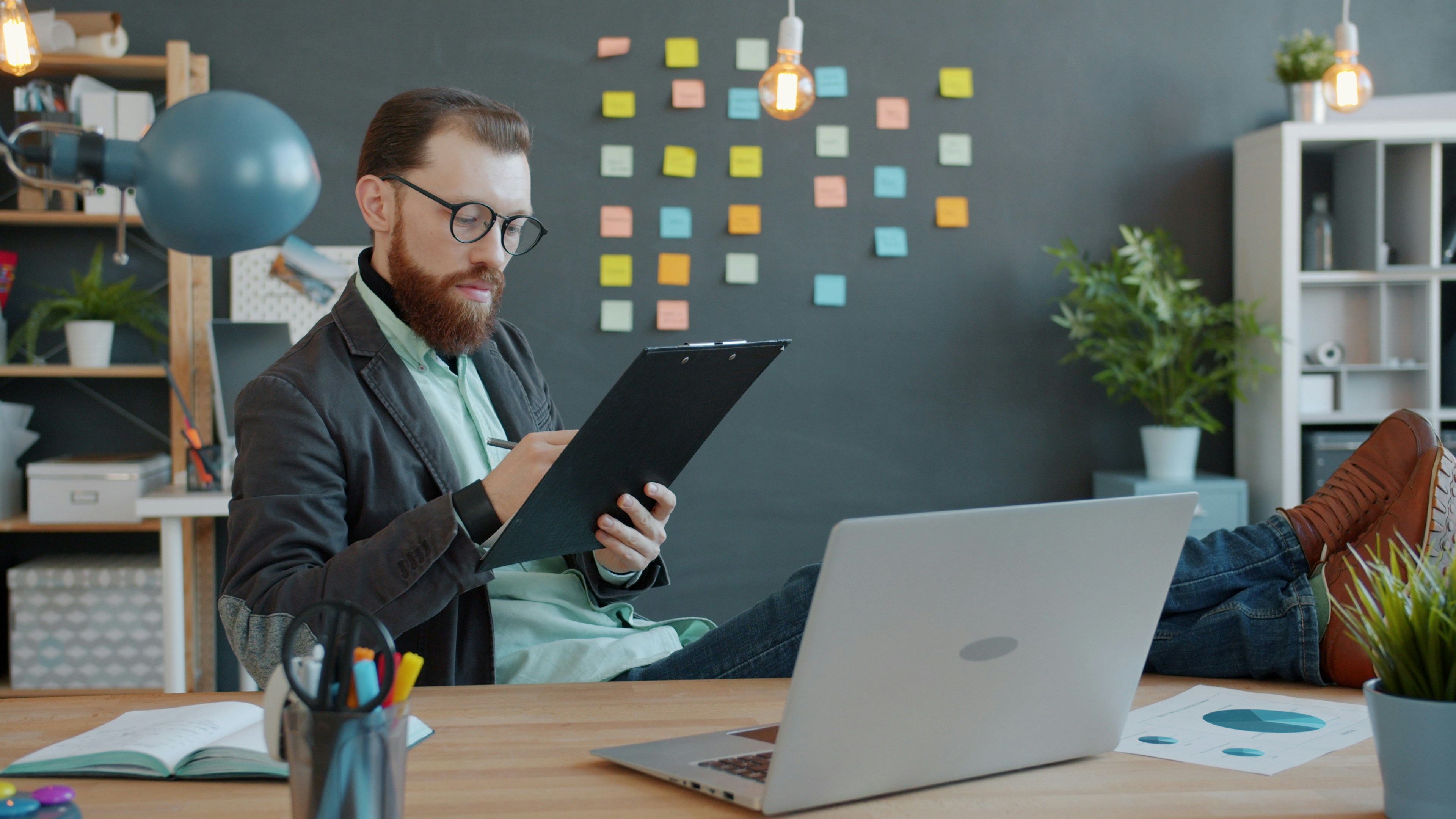Learn@Home - Mann sitzt mit Laptop und Schreibunterlage am Arbeitsplatz und entwickelt kreative Ideen und Konzepte.Kreative Ideen entwickeln und strukturiert umsetzen